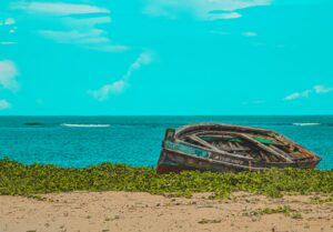 A traditional boat on a Kenya coast beach, representing independent local hospitality businesses