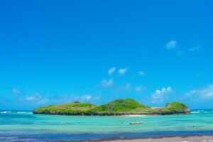 A green island on a blue sea, the kind of setting a dive or watersports operator would highlight